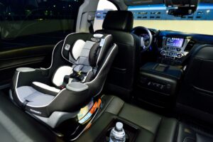 Interior of a car featuring a child safety seat and illuminated dashboard, captured at night.