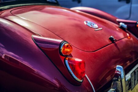 Close-up of a restored red classic MG car's tail light showcasing vintage automotive design.