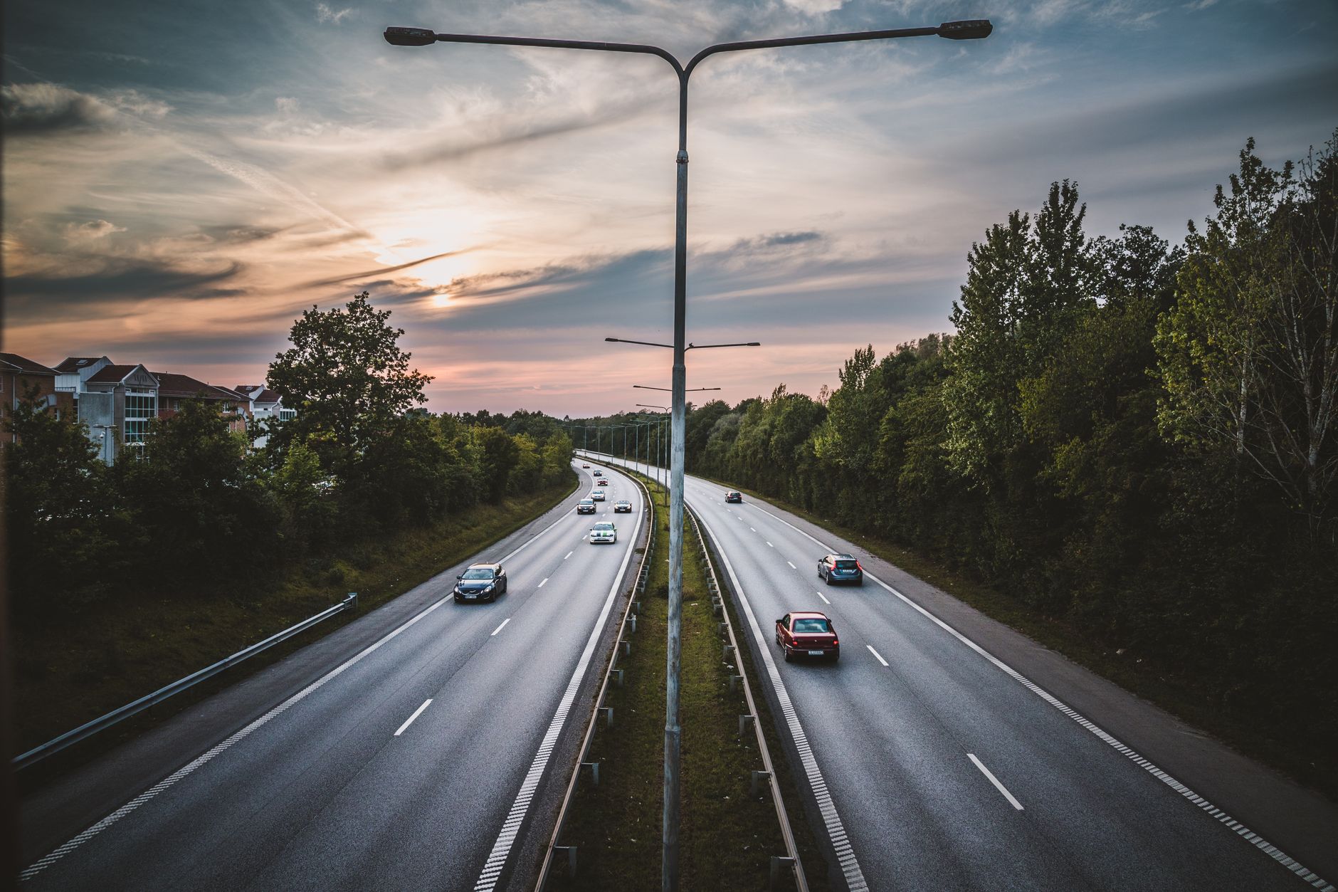 Vue aérienne d'une autoroute à Lund, Suède, avec des voitures et un ciel de coucher de soleil spectaculaire.